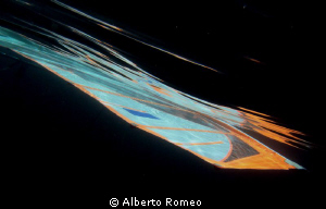 The sail of a windsurf underwater reflecting on the surfa... by Alberto Romeo 